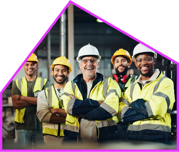 Une équipe de chantier en casques et vestes haute visibilité, bras croisés, souriante