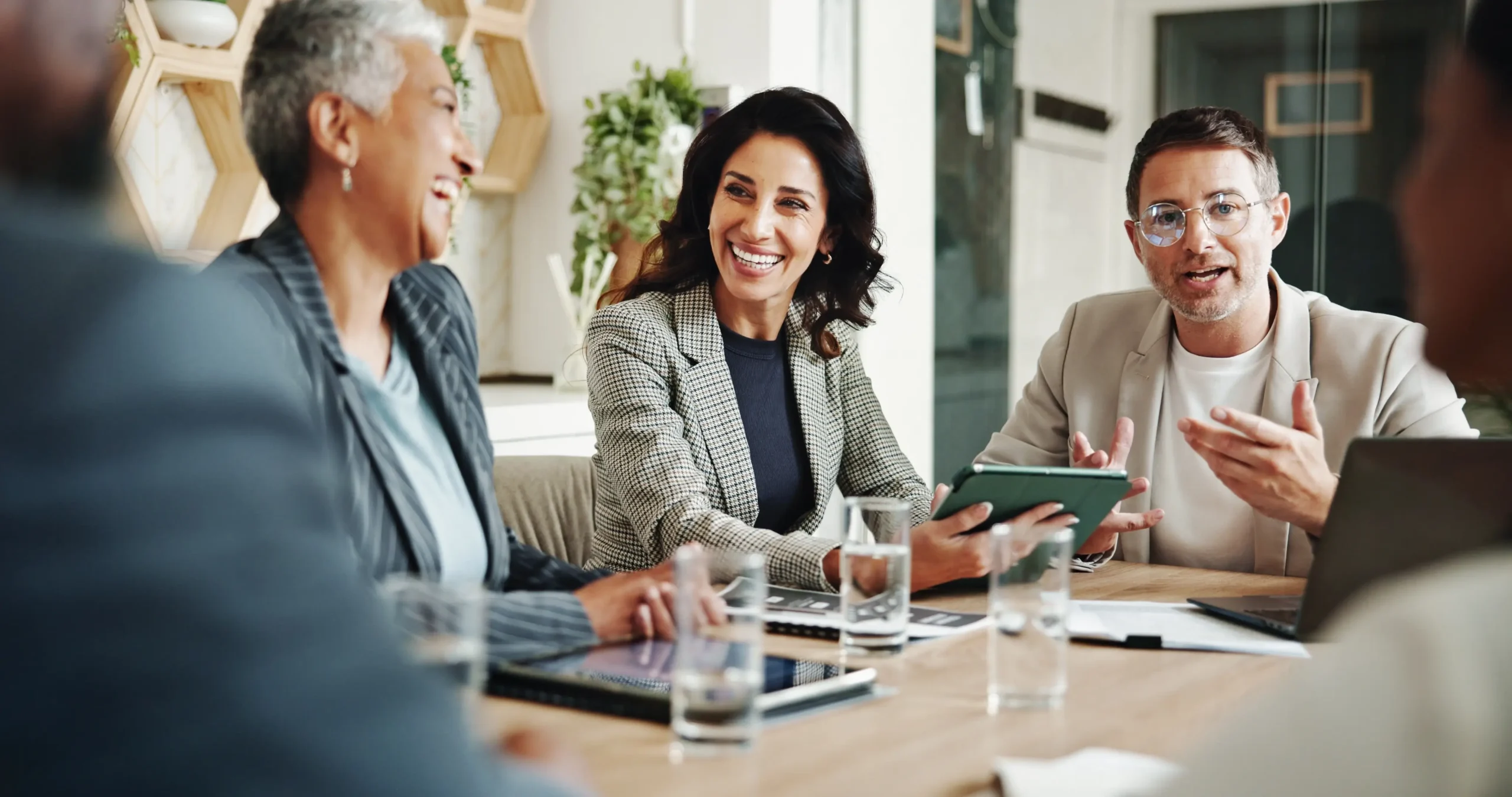 Colleagues smiling and talking together in a bright office.